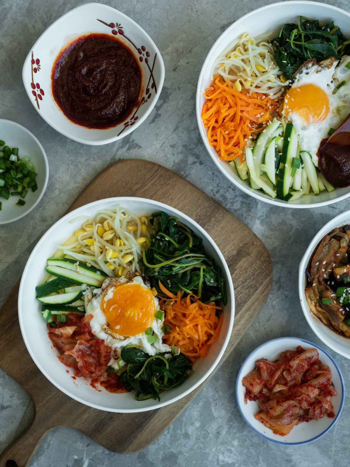 Stock photo of bibimbap bowls with vegetables, egg and gochujang — placeholder, not their kitchen