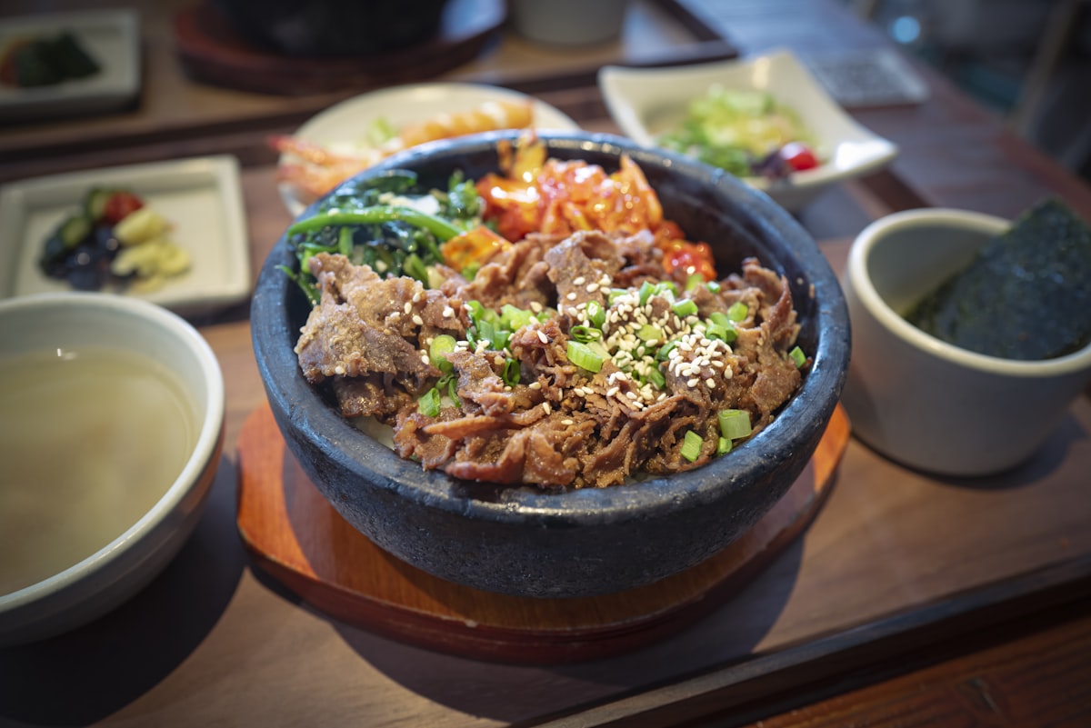 Stock photo of beef bulgogi in a stone bowl with sesame and scallions — placeholder, not their kitchen